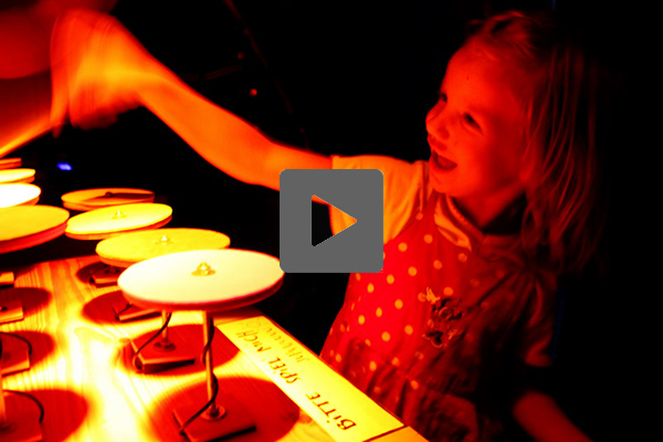 child moving hand towards an electronic marimba